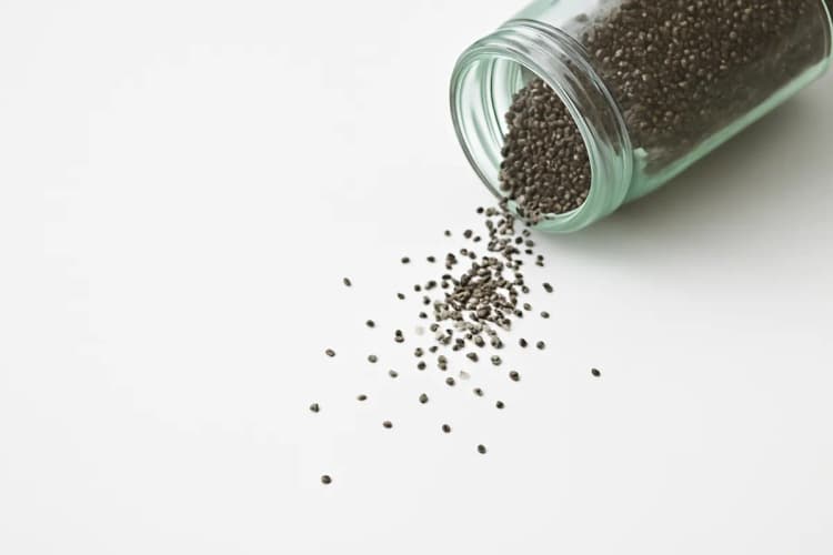 Grãos de chia caindo de um pote, detalhe