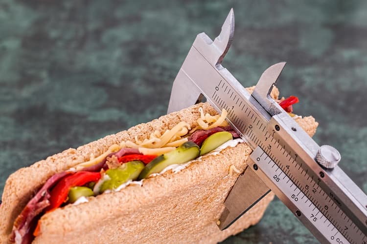 mulher jovem planejando refeições com um aplicativo de calculadora de calorias no tablet